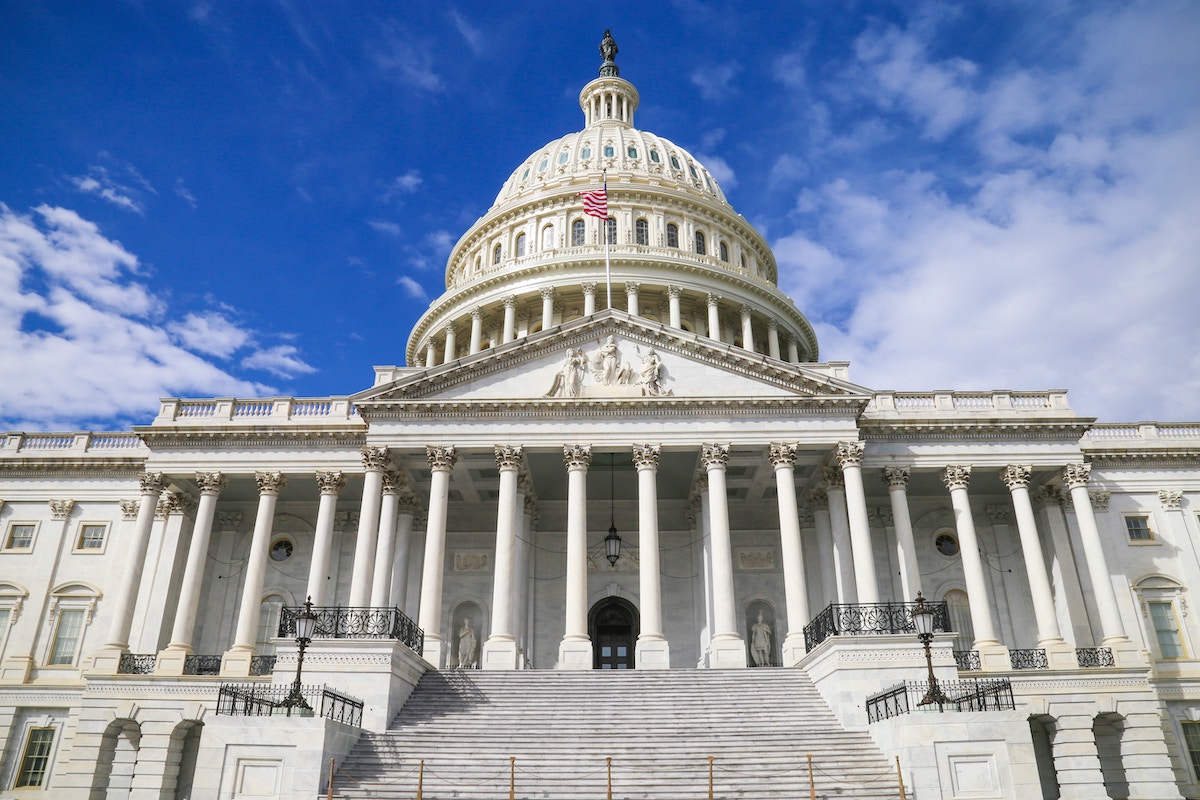 Photo of the White House with blue sky behind