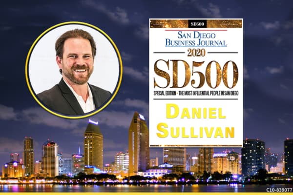 Daniel Sullivan smiling over downtown San Diego at night with SDBJ award details