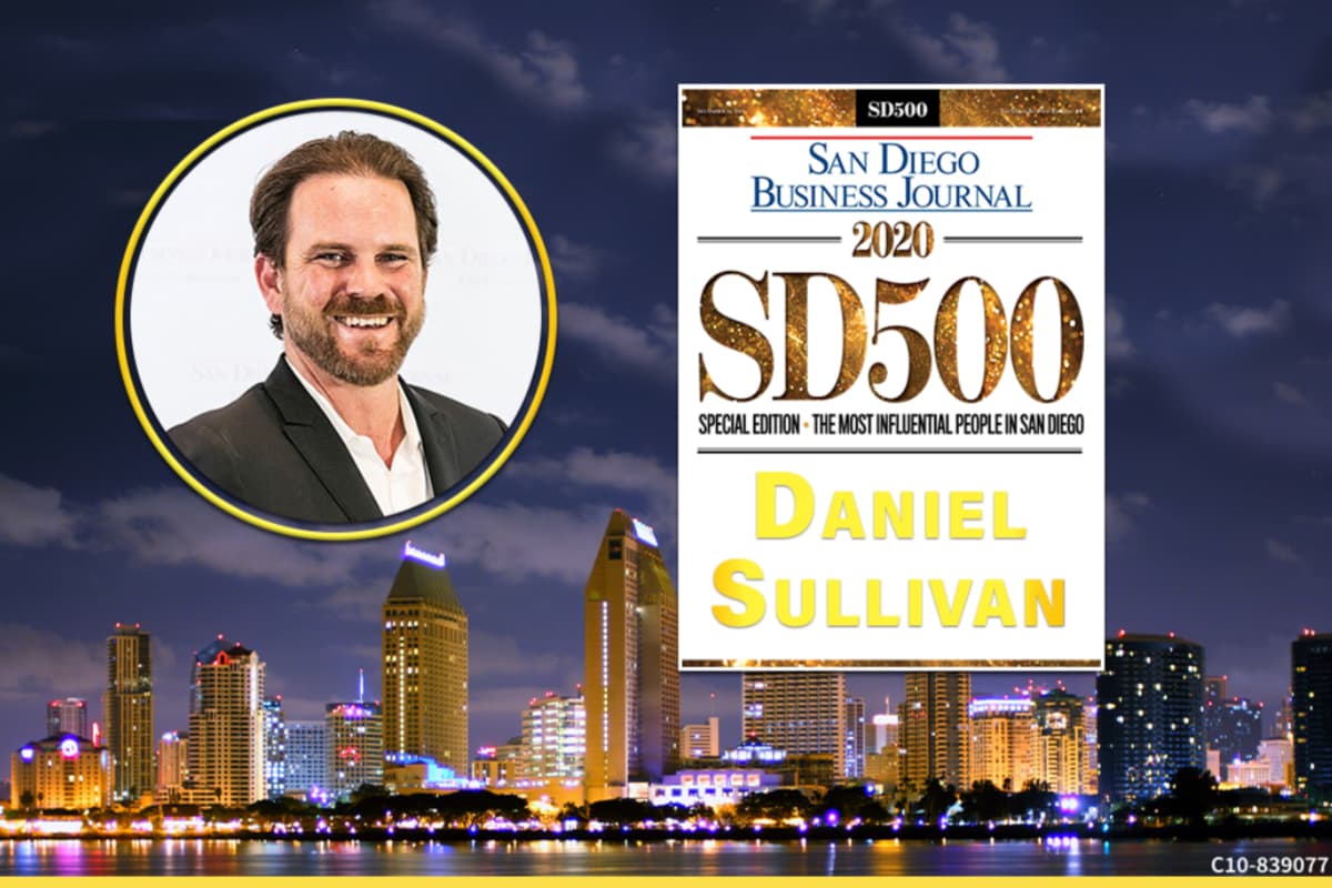 Daniel Sullivan smiling over downtown San Diego at night with SDBJ award details