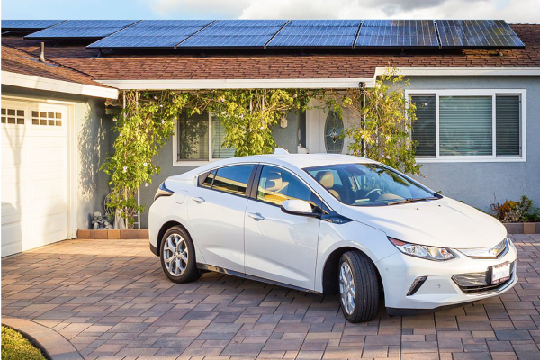Photo of electric vehicle parked in driveway of solar powered home
