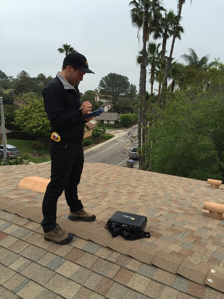 Photo of Project Developer on rooftop taking shade measurements and checking roof condition