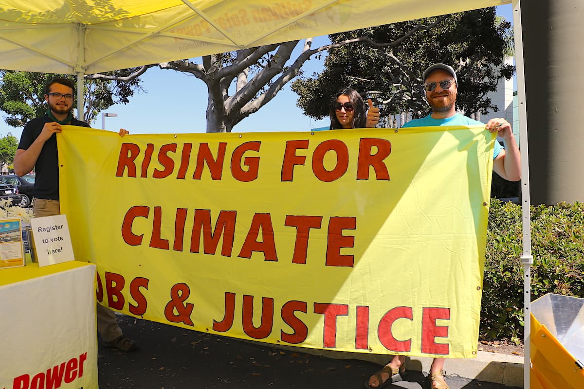 Photo of walkout supporters holding Rising For Climate Jobs and Justice banner