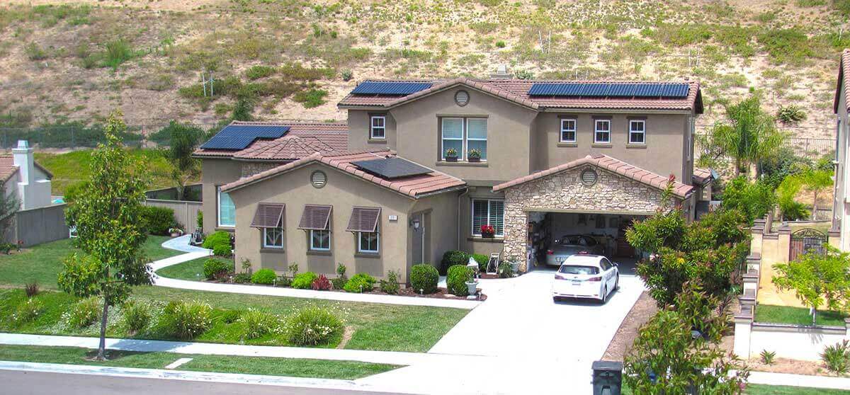 Photo of two-story home with solar panels on the tiled rooftop